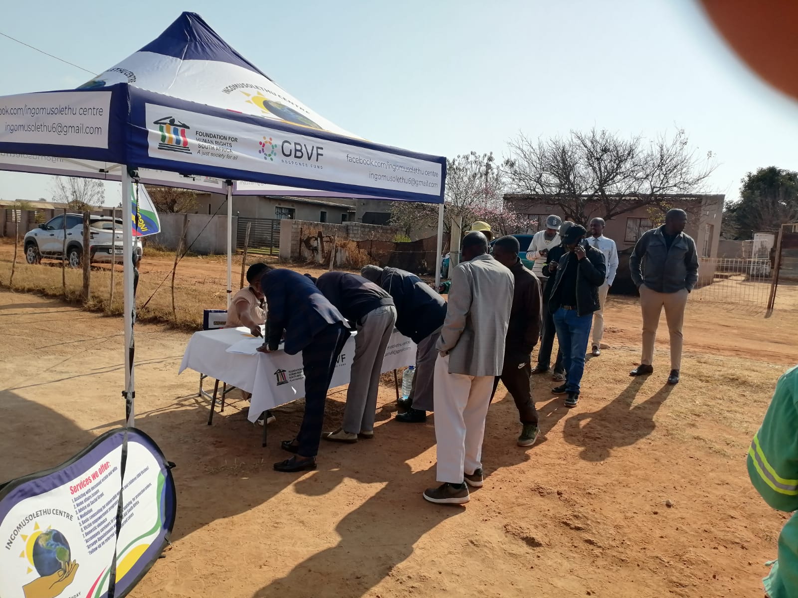 Community outreach desk under a gazebo during a GBVF campaign