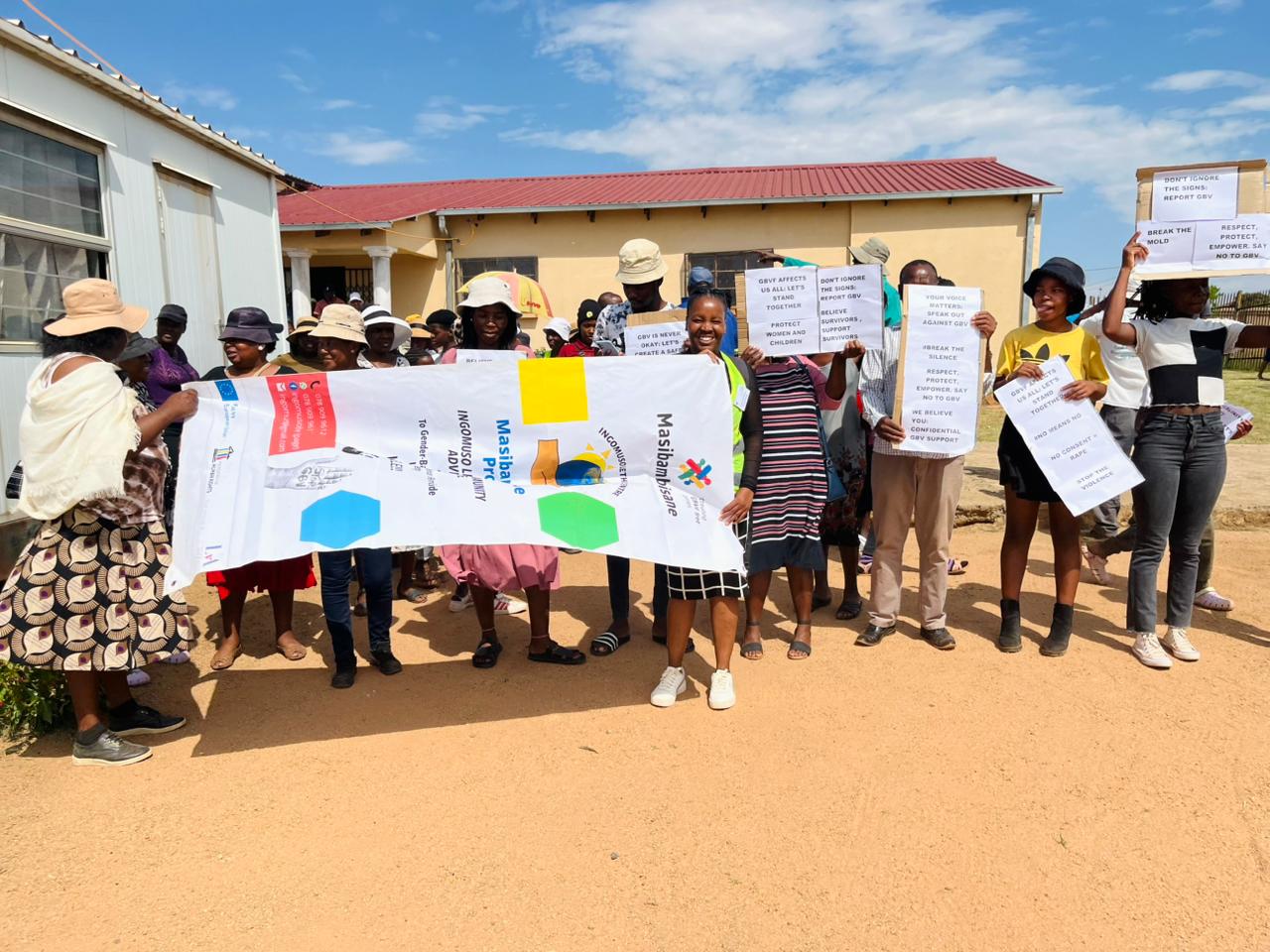 Community members holding campaign posters at a GBVF awareness event