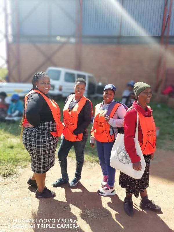 Service delivery monitors in reflective vests during community outreach